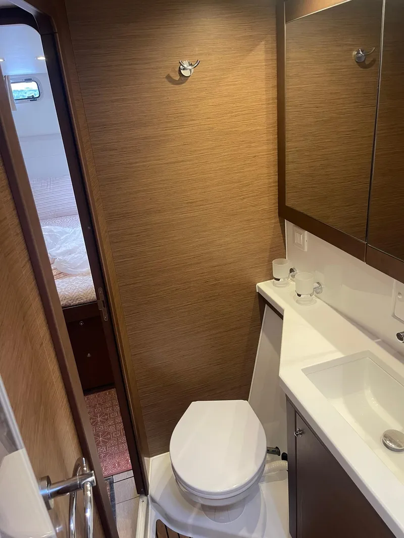 Slide: The Image of 2019 Lagoon 450 F yacht bathroom with modern fixtures and wood paneling. - 21