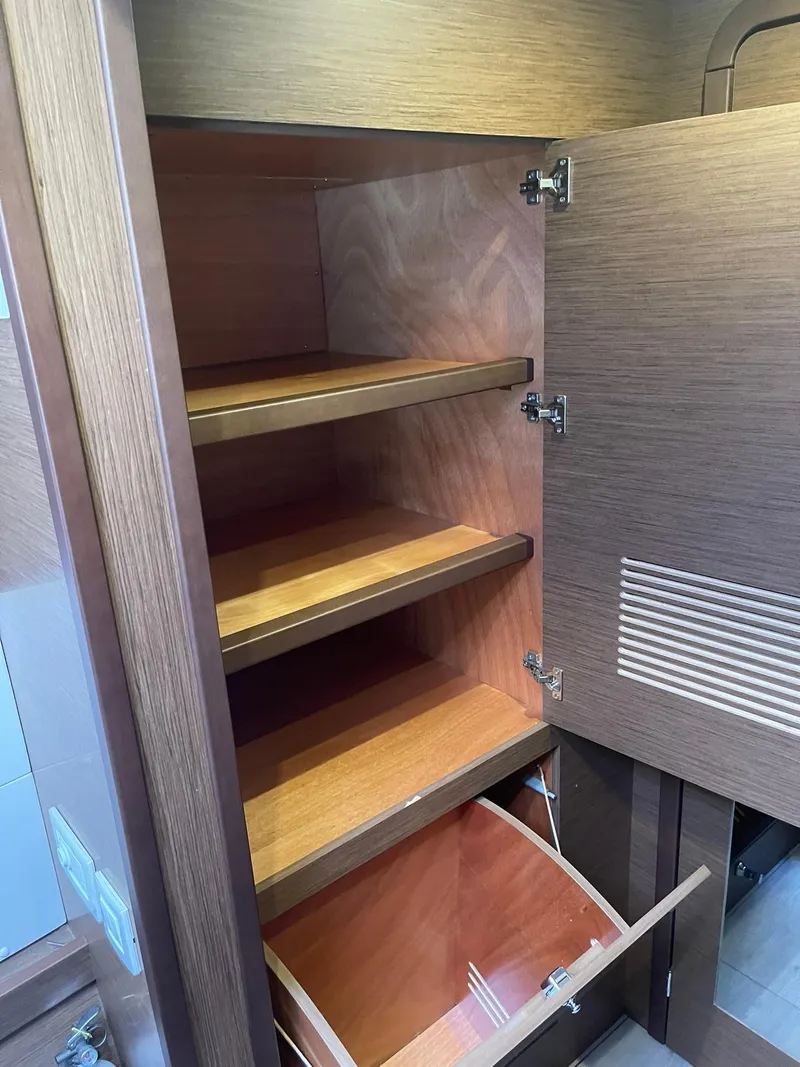 Slide: The Image of Wooden storage cabinet with shelves and drawer in 2019 Lagoon 450 F yacht. - 25