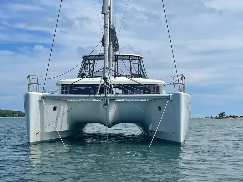 Slide: The Image of 2019 Lagoon 450 F catamaran on calm water under a cloudy sky. - 3