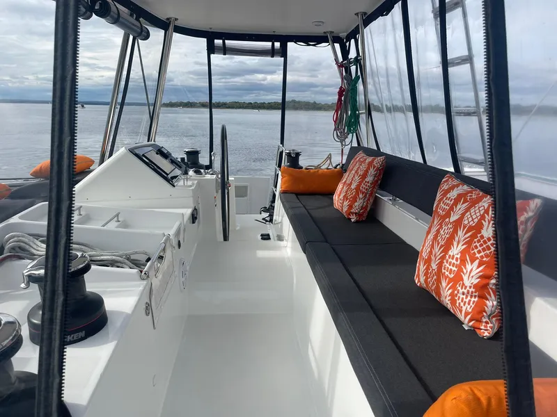Slide: The Image of 2019 Lagoon 450 F yacht interior with seating, orange cushions, and ocean view. - 30