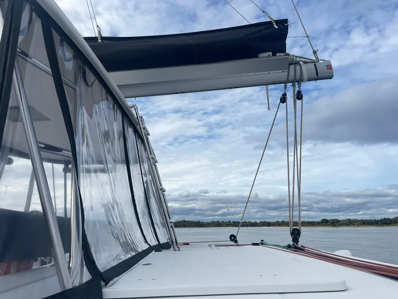 Slide: The Image of Lagoon 450 F catamaran, 2019 model, with sails down, on a calm waterway under a cloudy sky. - 32