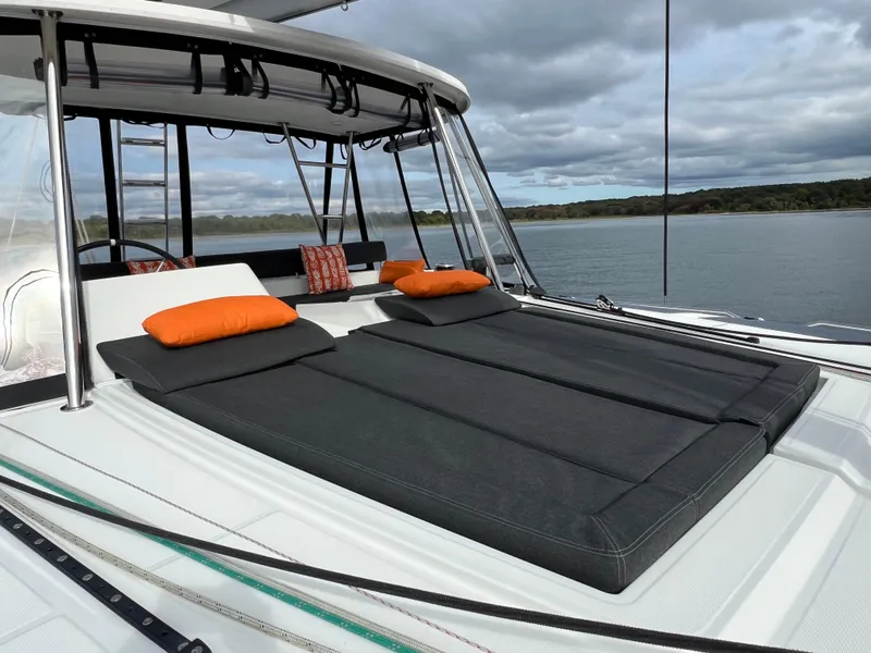 Slide: The Image of 2019 Lagoon 450 F catamaran with cushioned sunbathing area and scenic water view. - 33