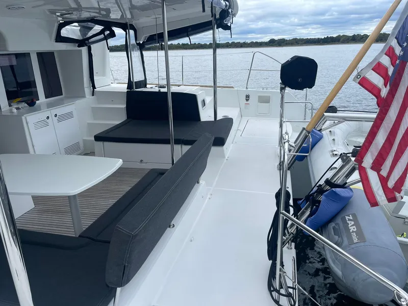Slide: The Image of 2019 Lagoon 450 F catamaran deck with seating, table, and American flag. - 44