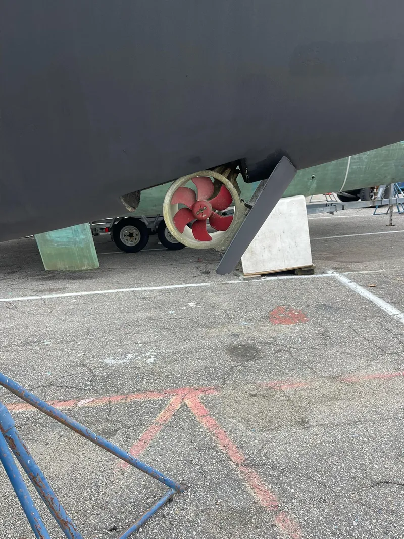 Slide: The Image of 2019 Lagoon 450 F catamaran with visible propeller and rudder in a boatyard. - 49