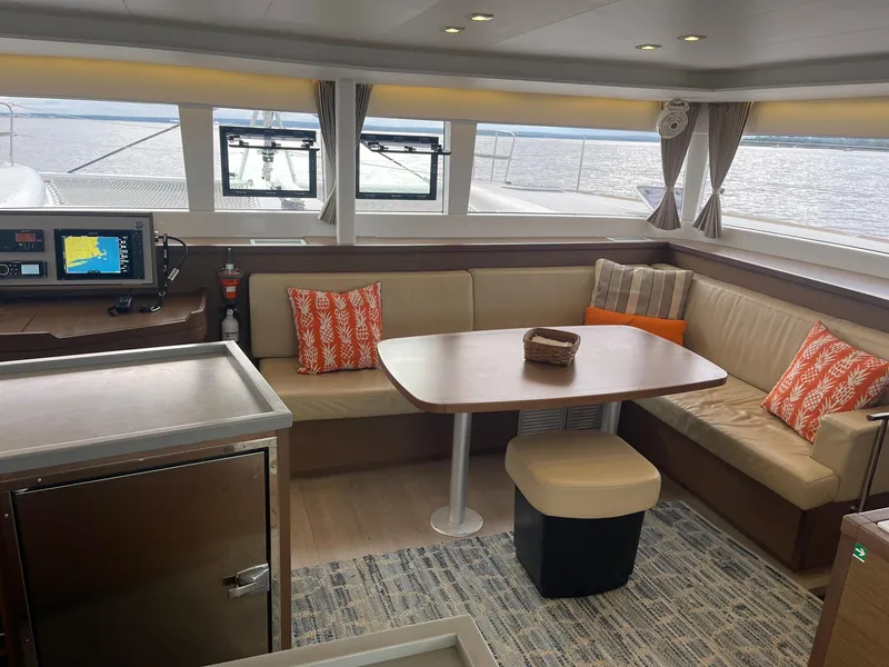 Slide: The Image of Interior of 2019 Lagoon 450 F catamaran with cozy seating and navigation equipment. - 7