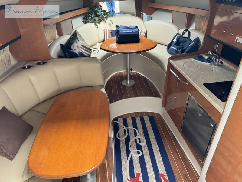 Slide: The Image of 2008 Chaparral Signature 290 interior with seating, table, kitchenette, and nautical decor. - 22