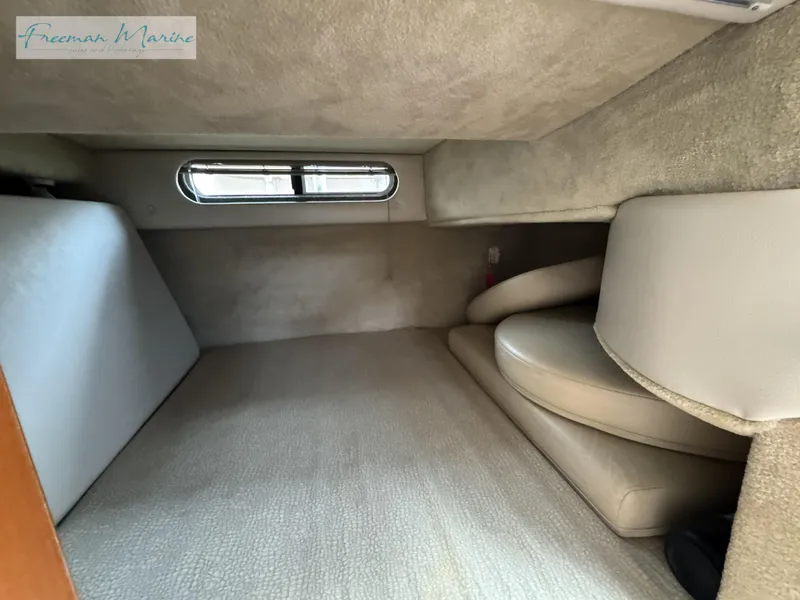 Slide: The Image of 2008 Chaparral Signature 290 cabin interior with beige upholstery and small window. - 26