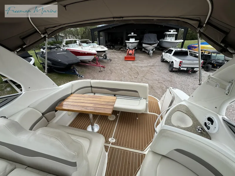 Slide: The Image of 2008 Chaparral Signature 290 interior with seating and table, overlooking marina with boats. - 34