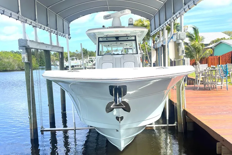 Slide: The Image of 2021 Sea Fox 368 Commander boat docked under a canopy by the water. - 0