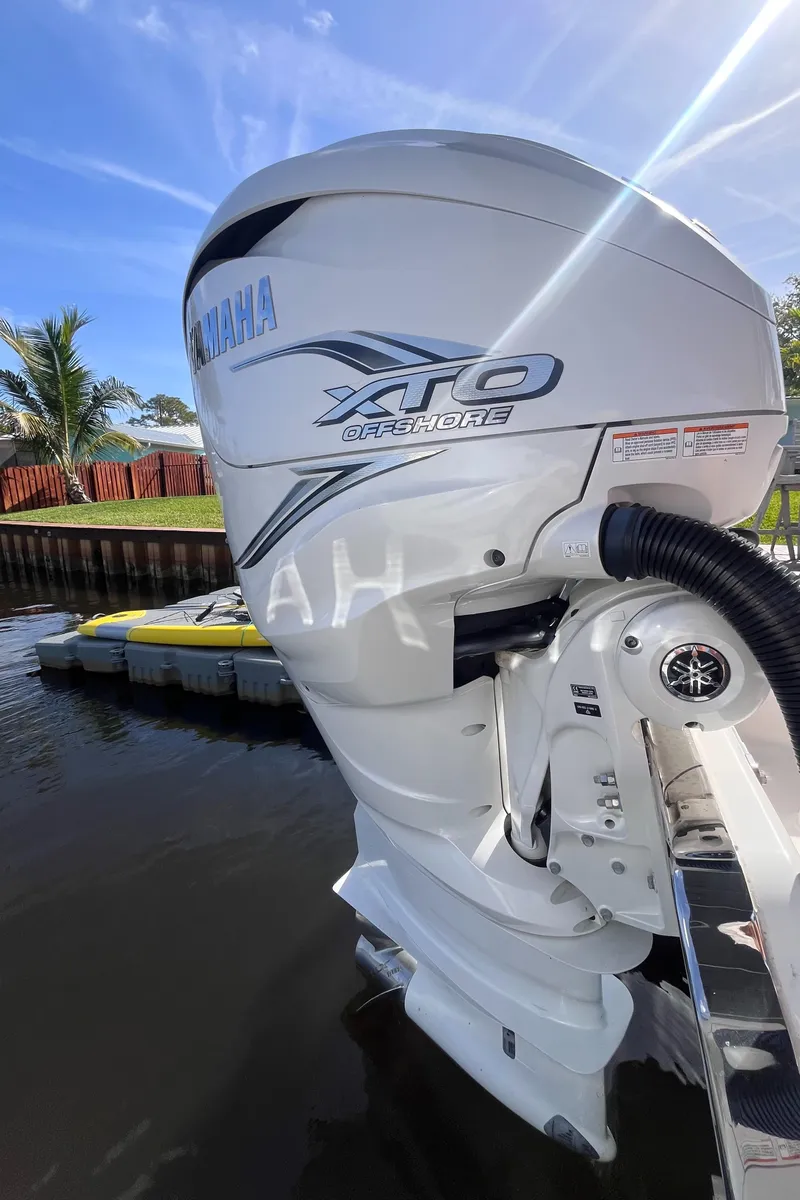 Slide: The Image of Yamaha XTO outboard motor on 2021 Sea Fox 368 Commander, docked by a sunny waterfront. - 2