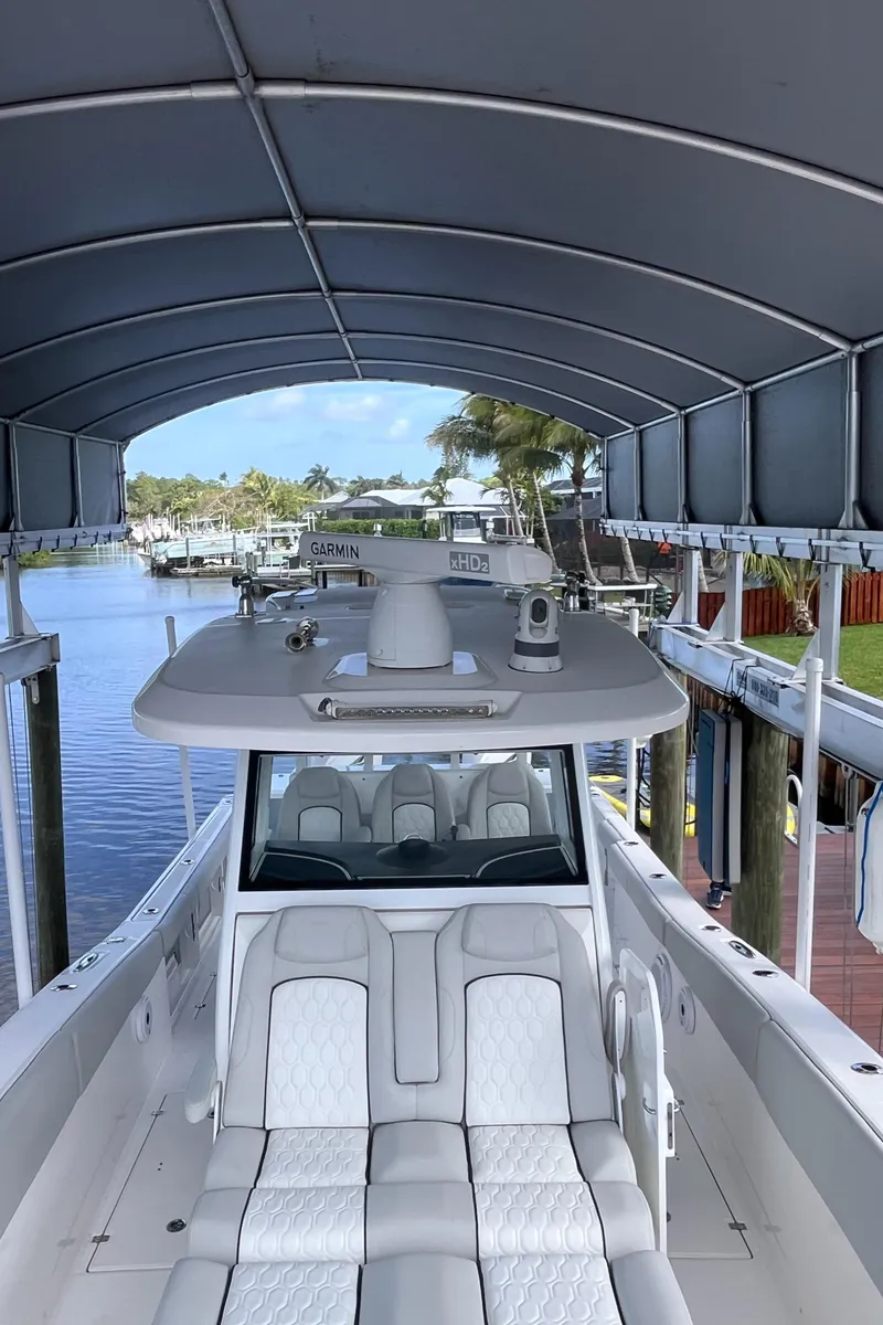 Slide: The Image of 2021 Sea Fox 368 Commander boat docked under canopy, featuring sleek design and comfortable seating. - 23