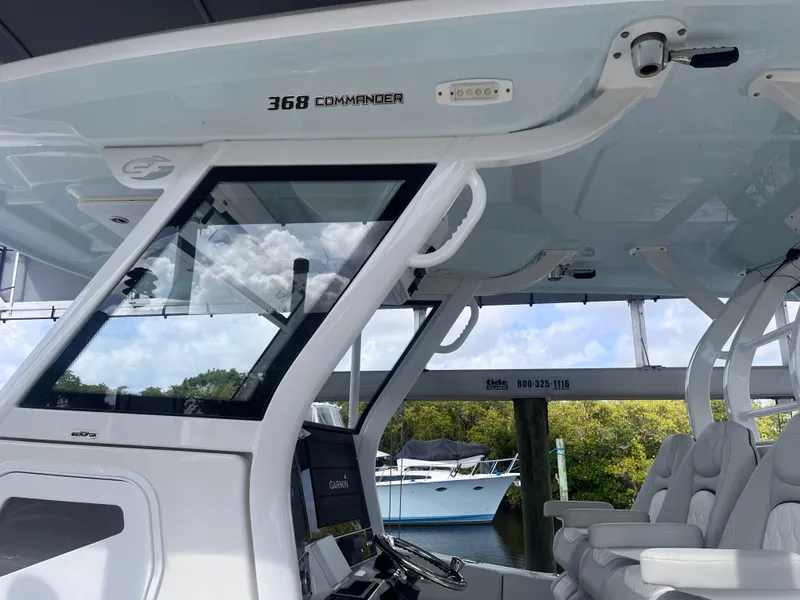 Slide: The Image of 2021 Sea Fox 368 Commander boat interior with helm and seating, docked near water. - 3