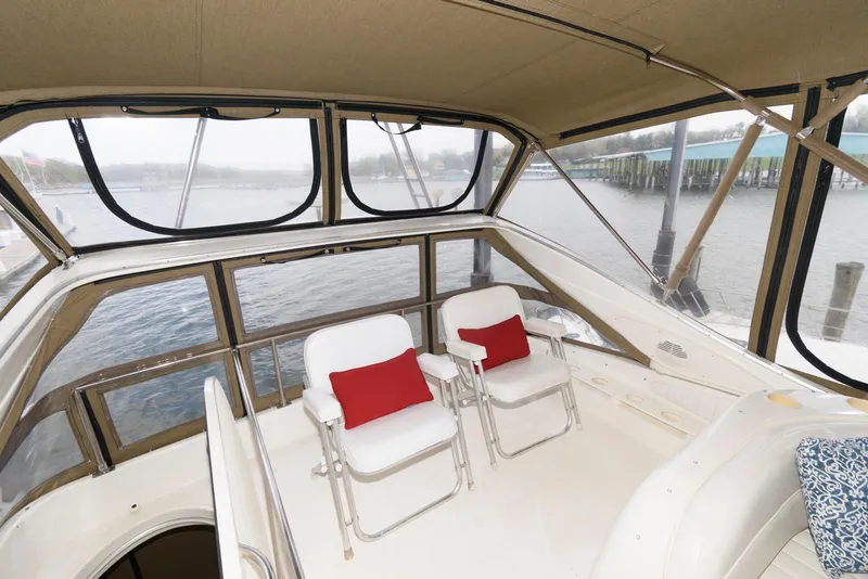 Slide: The Image of 2001 Maxum 4100 SCB yacht interior with two white chairs and red cushions. - 10