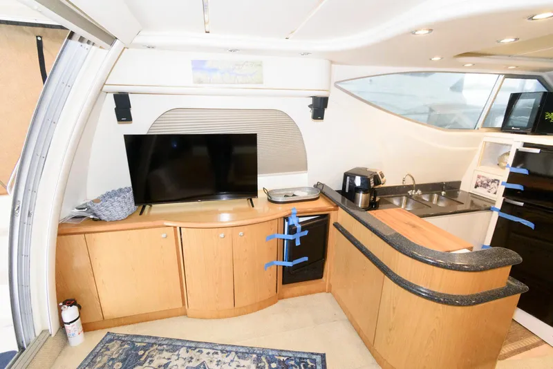 Slide: The Image of Interior of 2001 Maxum 4100 SCB yacht with TV, kitchenette, and modern amenities. - 14
