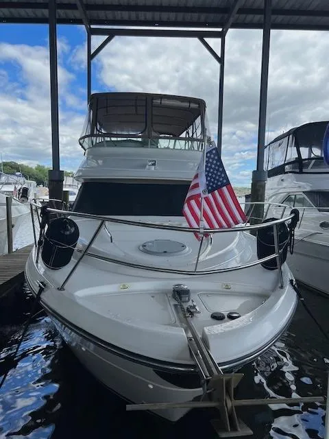 Slide: The Image of 2001 Maxum 4100 SCB yacht docked under a covered marina with an American flag. - 3