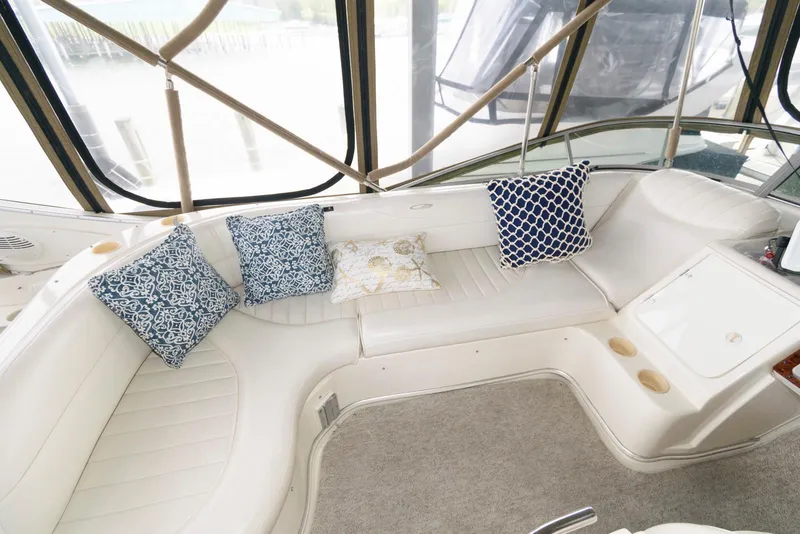 Slide: The Image of 2001 Maxum 4100 SCB yacht interior with cushioned seating and decorative pillows. - 6