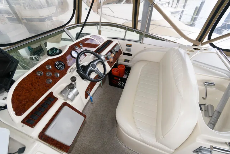 Slide: The Image of 2001 Maxum 4100 SCB boat cockpit with white seating and wood-accented control panel. - 7