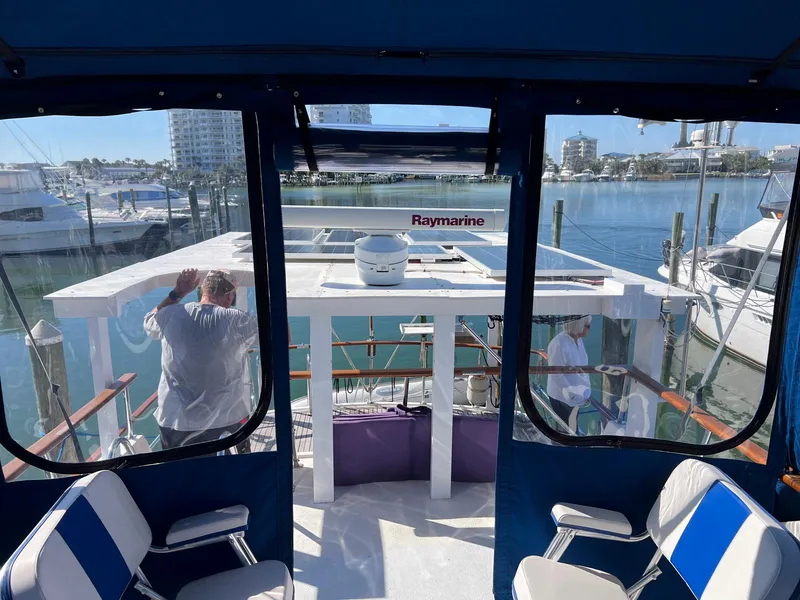 Slide: The Image of 1983 Lindmark 39 Trawler interior view with marina background, featuring Raymarine equipment. - 14