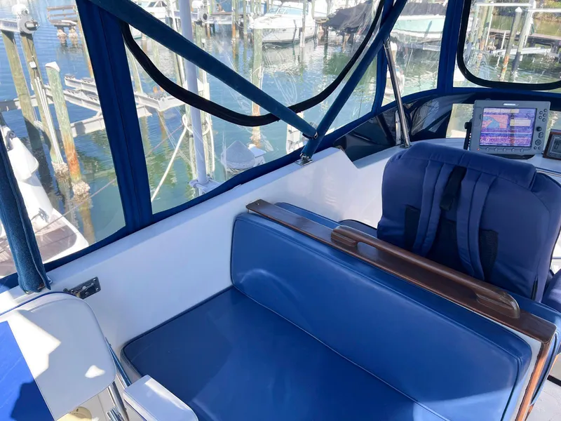 Slide: The Image of 1983 Lindmark 39 Trawler cockpit with blue seating and navigation equipment. - 18