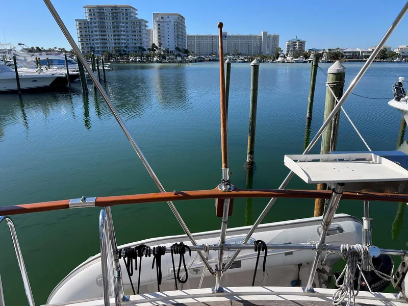 Slide: The Image of 1983 Lindmark 39 Trawler docked in a marina with waterfront buildings in the background. - 28