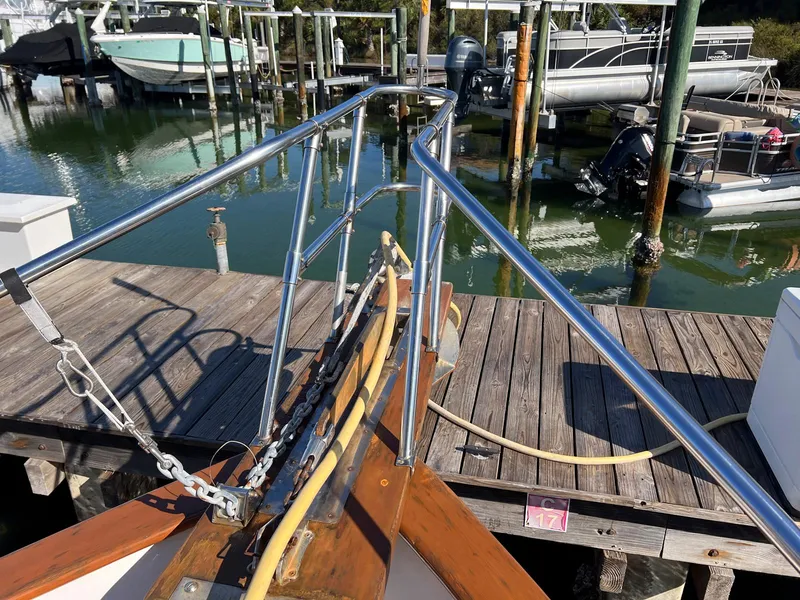 Slide: The Image of 1983 Lindmark 39 Trawler docked, showing bow and railing, with marina background. - 32