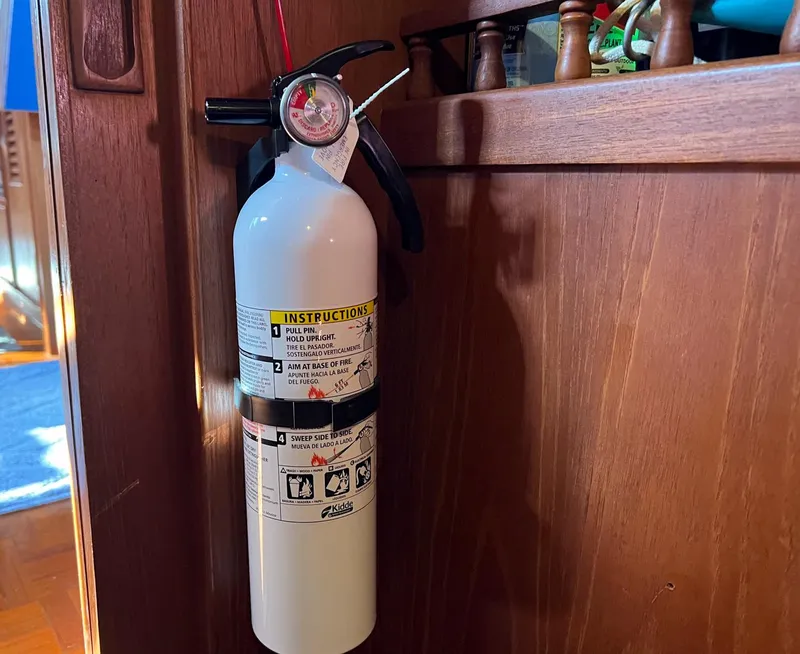 Slide: The Image of Fire extinguisher mounted on 1983 Lindmark 39 Trawler wooden interior. - 38