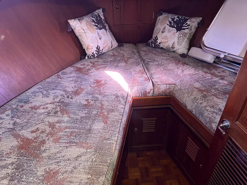 Slide: The Image of 1983 Lindmark 39 Trawler cabin with twin beds and decorative pillows. - 39