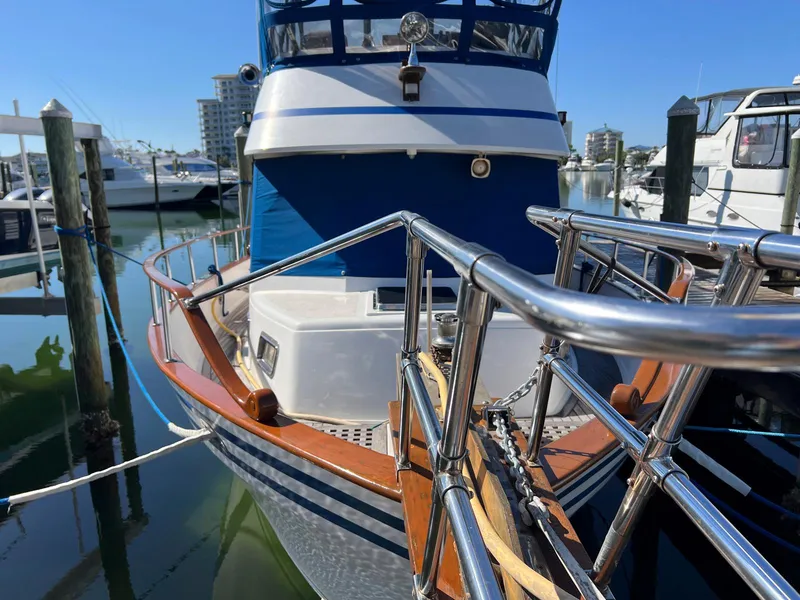 Slide: The Image of 1983 Lindmark 39 Trawler docked at marina, showcasing polished railings and classic design. - 4