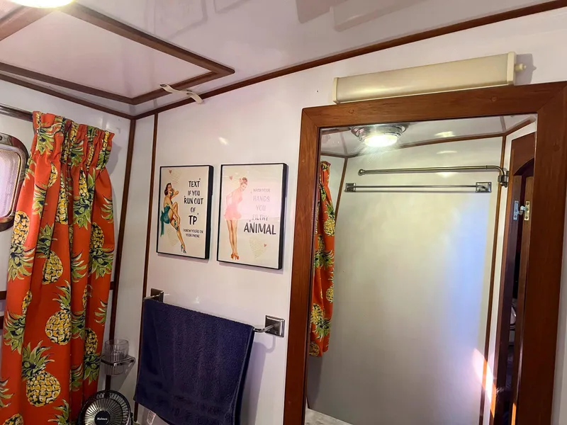 Slide: The Image of 1983 Lindmark 39 Trawler bathroom with pineapple curtains and vintage wall art. - 40