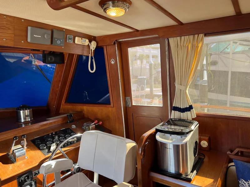 Slide: The Image of 1983 Lindmark 39 Trawler interior with helm, controls, and seating. - 49