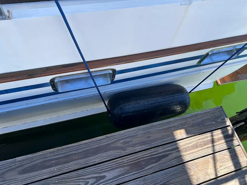 Slide: The Image of 1983 Lindmark 39 Trawler docked with fender, wooden pier, and green water. - 8