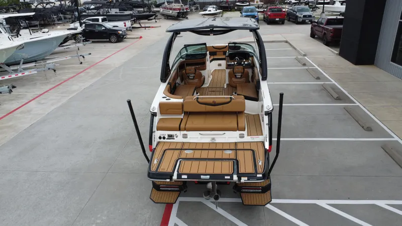 Slide: The Image of 2022 Chaparral 28 Surf boat with tan interior, parked in a marina lot. - 17