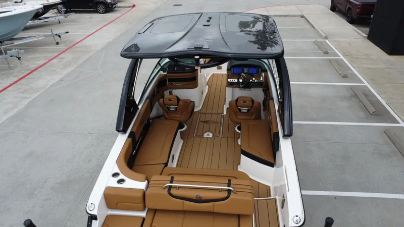 Slide: The Image of 2022 Chaparral 28 Surf boat with spacious interior and modern design in a parking area. - 20