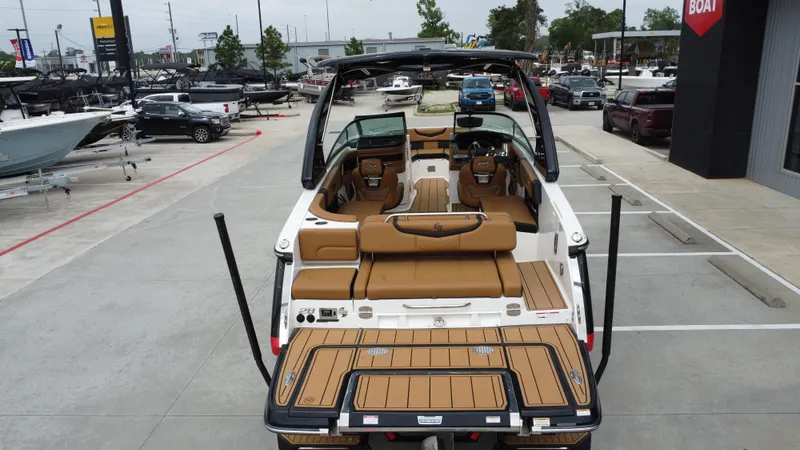 Slide: The Image of 2022 Chaparral 28 Surf boat with tan interior, displayed at a dealership. - 21