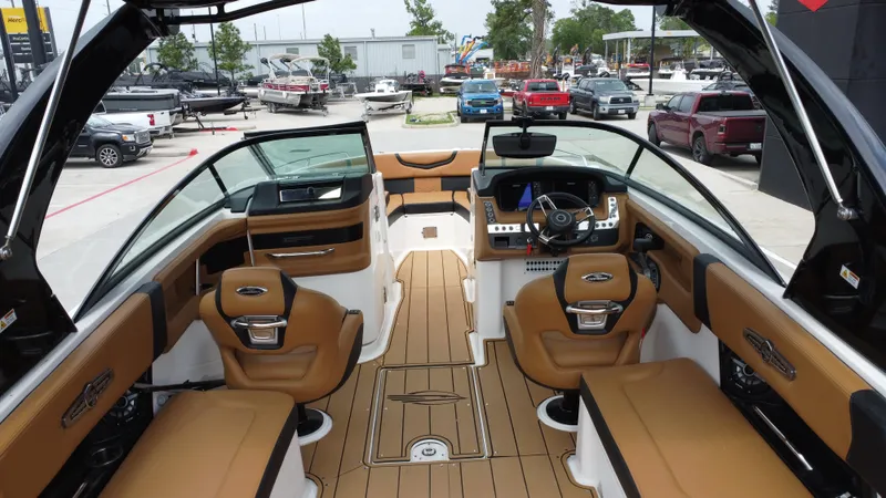 Slide: The Image of Interior view of 2022 Chaparral 28 Surf boat with tan seating and modern dashboard. - 22