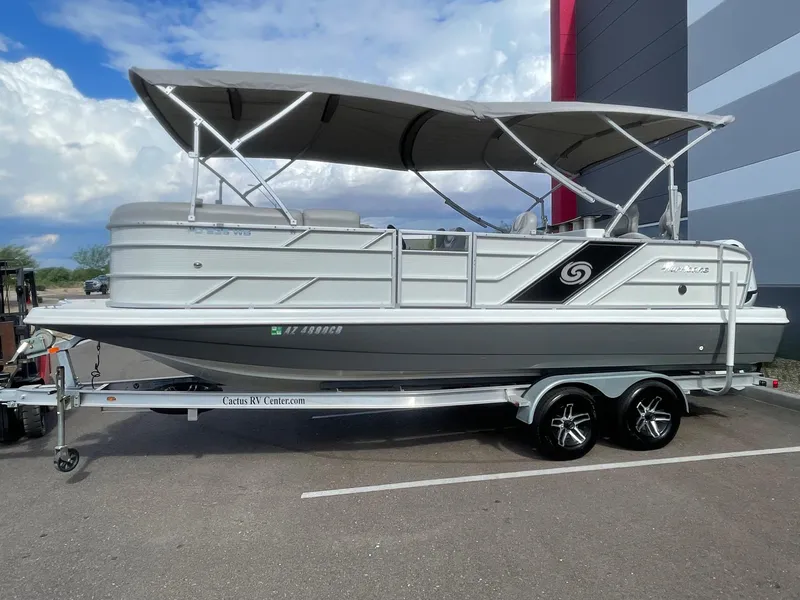 Slide: The Image of 2020 Hurricane FunDeck 236WB OB boat on trailer, parked outdoors under cloudy sky. - 2