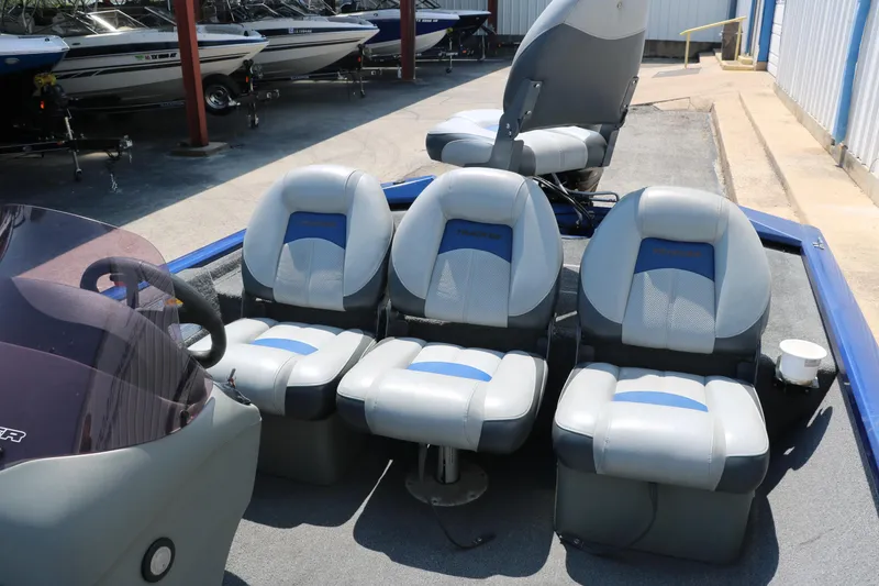 Slide: The Image of 2014 Bass Tracker PT175TF boat seats, gray and blue, in a marina setting. - 23