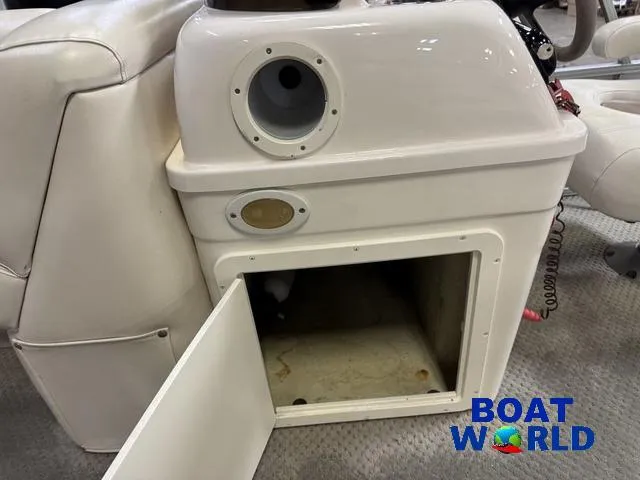 Slide: The Image of 2008 SunChaser 8522 boat interior with open storage compartment and steering console. - 18