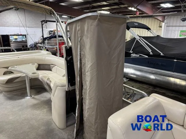 Slide: The Image of 2008 SunChaser 8522 pontoon boat interior with seating and privacy curtain in showroom. - 25