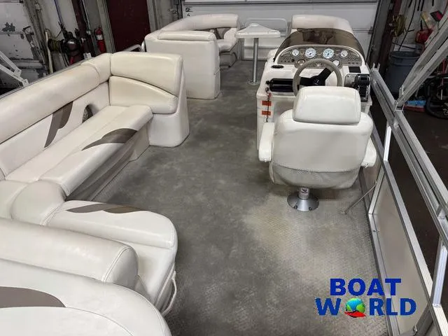 Slide: The Image of 2008 SunChaser 8522 pontoon boat interior with beige seating and steering console. - 6