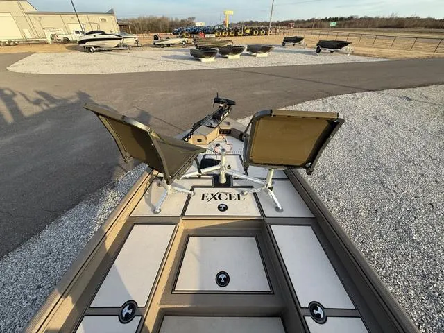 Slide: The Image of 2022 Excel Boats Bay Pro 220 with dual seats, parked on gravel lot. - 6