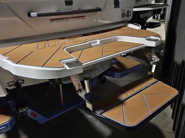 Slide: The Image of 2025 Malibu 23 LSV boat swim platform with teak-style decking and step detail. - 14