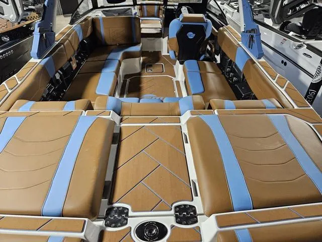 Slide: The Image of 2025 Malibu 23 LSV boat interior with brown and blue seating, showcasing luxury design. - 16