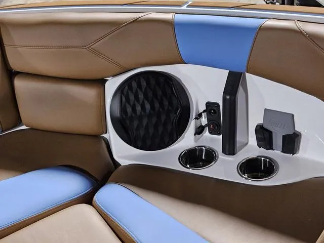 Slide: The Image of Interior of 2025 Malibu 23 LSV boat with speaker, cup holders, and blue-brown seating. - 18
