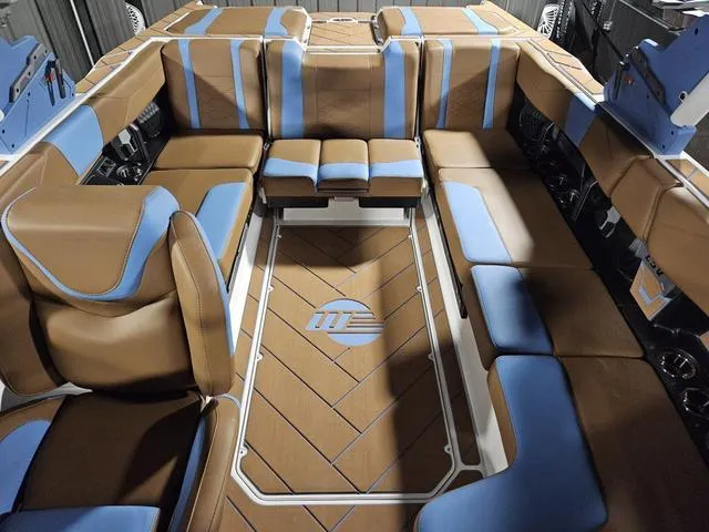 Slide: The Image of Luxurious interior of 2025 Malibu 23 LSV boat with brown and blue seating. - 24