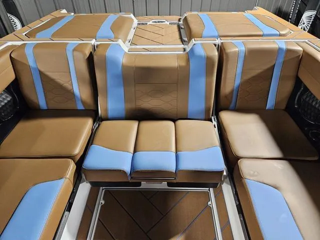 Slide: The Image of 2025 Malibu 23 LSV boat interior with brown and blue seating arrangement. - 26