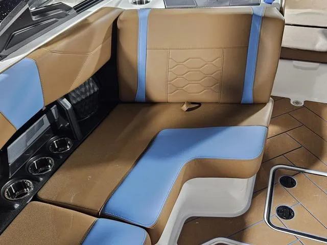 Slide: The Image of 2025 Malibu 23 LSV interior with brown and blue seating, cup holders, and modern design. - 29
