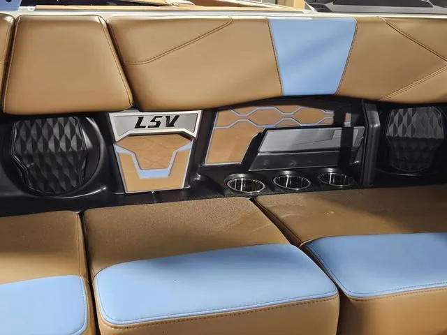 Slide: The Image of 2025 Malibu 23 LSV interior with tan and blue seating, cup holders, and stylish design elements. - 30