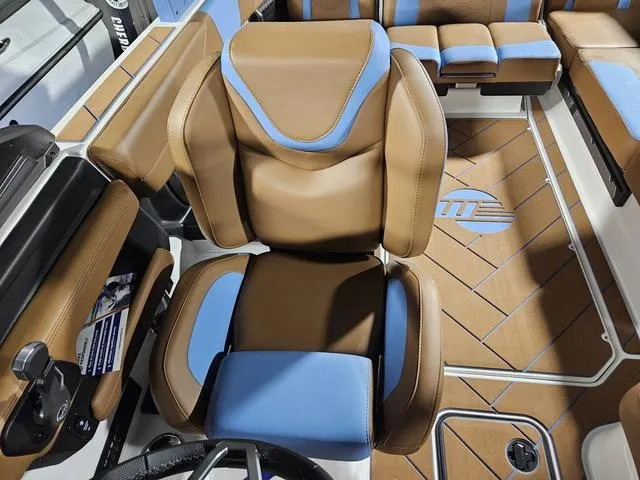 Slide: The Image of 2025 Malibu 23 LSV boat interior with brown and blue seating and modern design. - 36