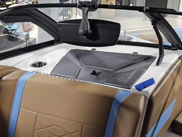 Slide: The Image of 2025 Malibu 23 LSV boat interior with brown and blue seating, cup holder, and dashboard. - 37